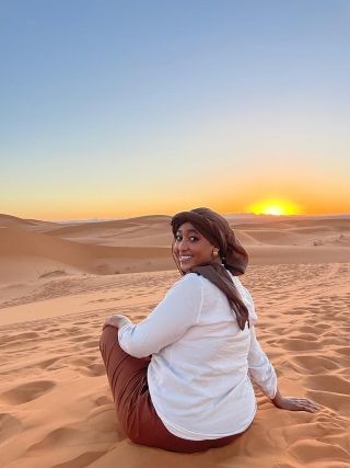 Student sitting on sandstone in Sahara Desert