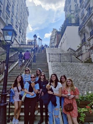 Students on a walking tour in Montmartre posing on stairs
