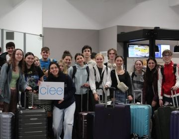 High school students at the airport holding CIEE sign