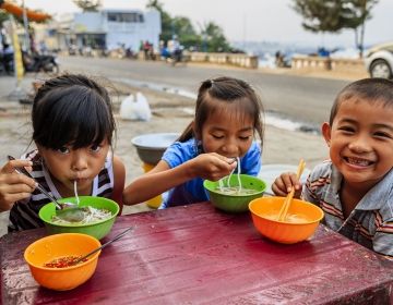 Vietnamese children eating outside
