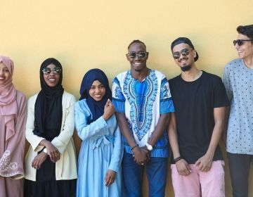 International students smiling against a wall in United Arab Emirates