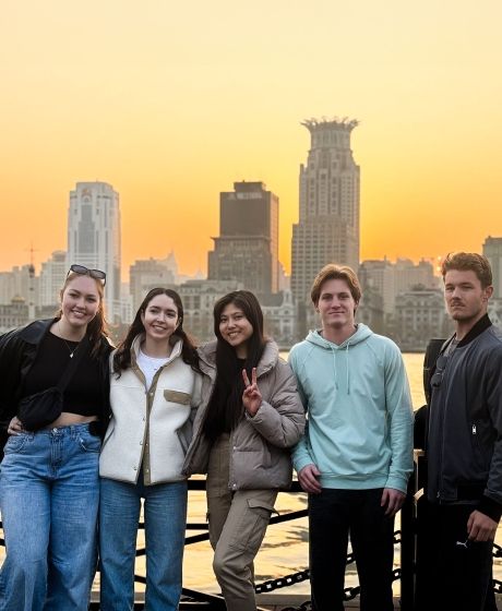 shanghai students posing with city skyline in background