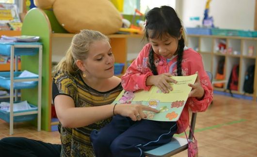 Teacher and student reading a book