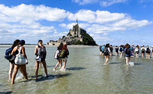 hssa rennes students walking in the low tide to mont st. michael