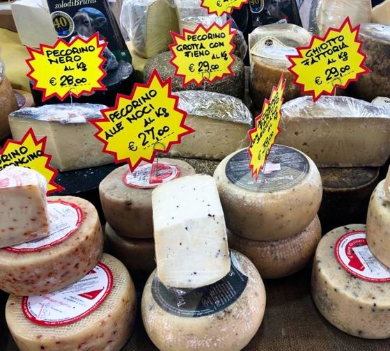 stacked cheeses at a market