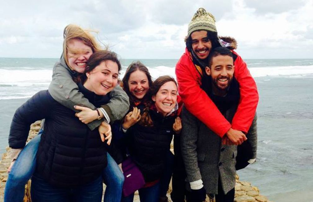 students piggyback by ocean rabat morocco