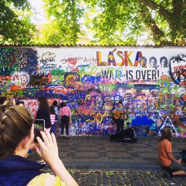 prague student taking picture of Lennon wall