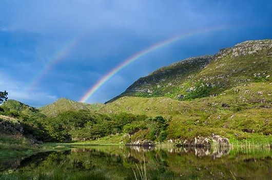 rainbow in ireland by the water and mountains