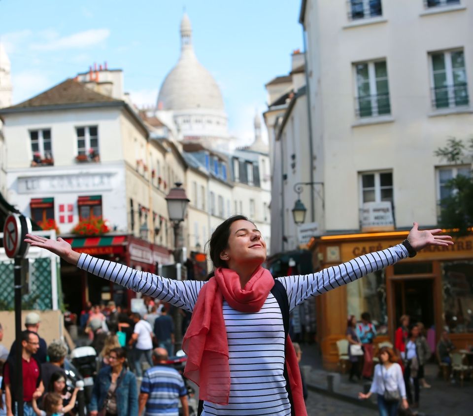 Happy girl with her arms outstretched in Paris