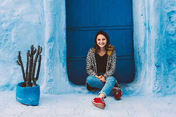 HSSA student in Rabat laughing in front of mosiac wall