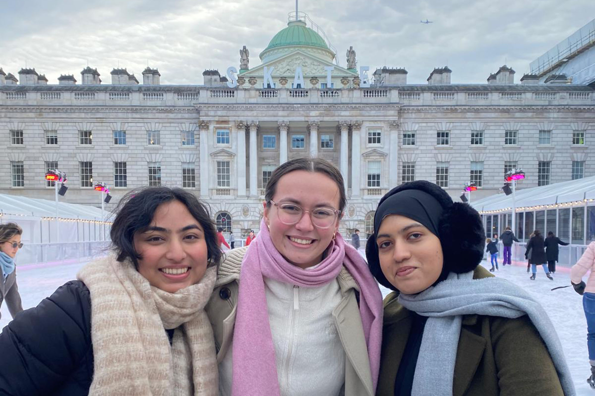 Three girls ice skating at Somerset House in the winter