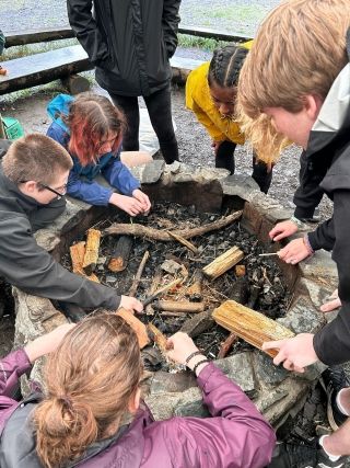 A group of students working together to make a fire