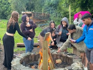 Students roasting their marshmallows in the bonfire
