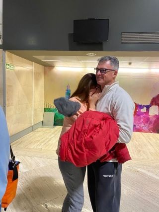 High school student saying goodbye to host parent at airport