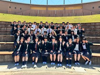Group shot of high school students in front of Japanese school