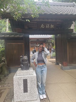 Picture of the author posing with a Maneki-neko statue at Gotokuji