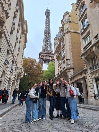 high school abroad students posing with eiffel tower in paris france