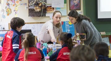 Teacher helping students in Spanish classroom
