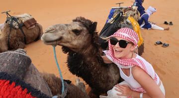 Student in the desert of Morocco posing with a camel