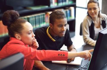 Students collaborating in class looking at a monitor