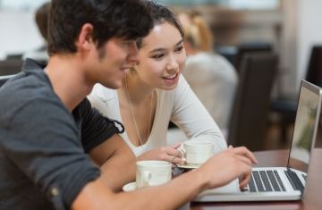 2 students working over laptop