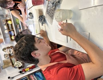 Student very focused on painting his design