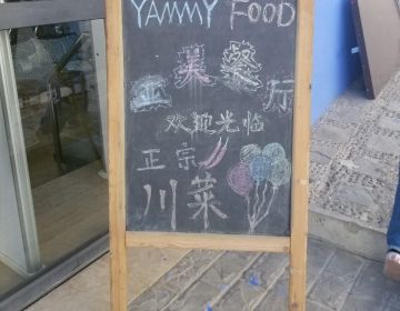 A chalk restaurant advertisement for "Yammy Food," featuring various languages in various scripts.