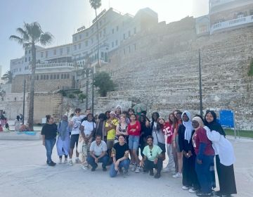 Students posing for picture in front of the Old Medina's stone walls in Tangier.