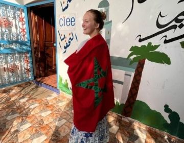 The author of the piece wrapping the Moroccan flag around herself in front of the CIEE Rabat office