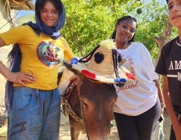 Marly and Ja'Niya posing with the family donkey