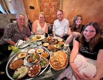 Two students and their host family at a Moroccan restaurant 