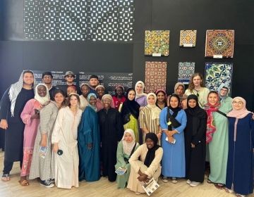 Students standing in a museum in traditional Moroccan dress