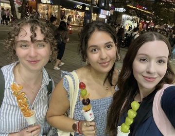 Us CIEE besties enjoying a street food called "Tanghulu" which is fruit on a stick that has been candied so the outside is crunchy.