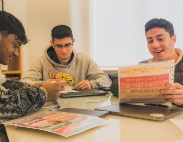 Students looking at worksheet in classroom on program