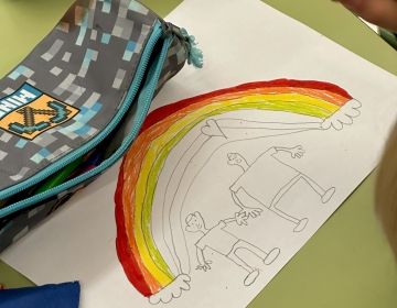 Kid drawing a cute rainbow