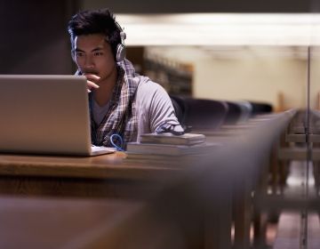 Student on laptop in dark library