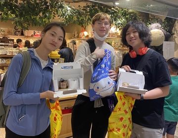 Global Navigators show off sweet treats from the Kirby Cafe while standing in front of the Studio Ghibli store at Tokyo Character Street.
