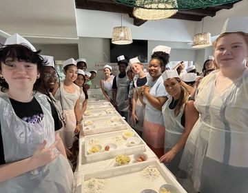 Students smiling waiting to roll out gnocchi dough