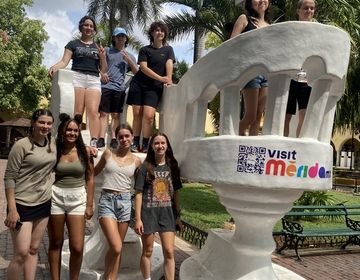 A group of students gather to take a picture in the iconic chairs.