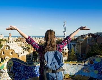 Young female student with arms raised looking at view of Barcelona