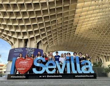 Gap year students posing with Sevilla sign in Spain