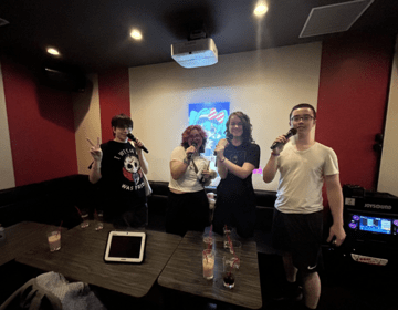 students posing with microphones at karaoke