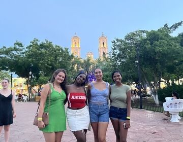 High school study abroad students in a park in front of a historic cathedral