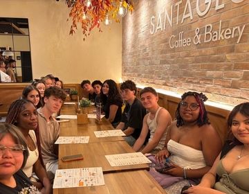 Students all sit together at a local cafe, laughing and getting to know one another!