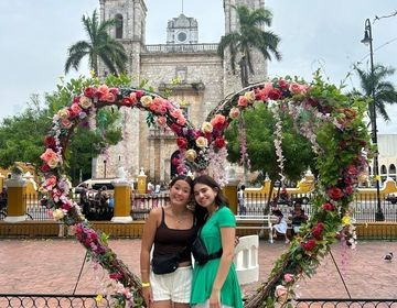 Two students standing in front of a floral heart
