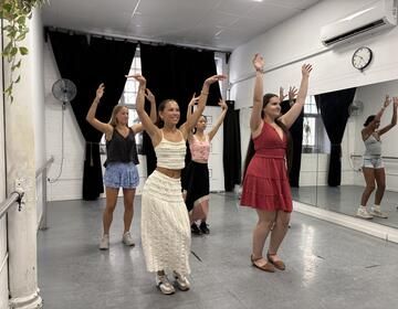 Group of students dancing flamenco with their arms up in the air