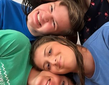 Four Smiling Faces Look at the Camera