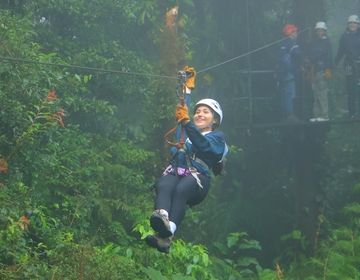 Women for Environmental Action student, Karina, ziplining across the cloud forest and smiling