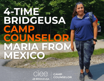 Maria M. of Mexico stands in front of the woods at Camp Sno-Mo in New Hampshire.