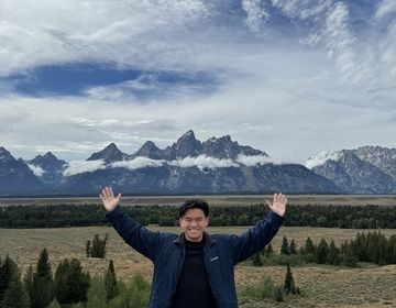 Yip Hern stands in front of Grand Teton National Park.